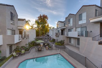 The woods community pool area at dusk with sun beginning to set behind the buildings - Photo Gallery 4