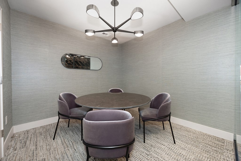 a meeting room with a table and chairs and a chandelier a meeting room with a table and chairs and a chandelier at Track 281 Apartments, California, 95811