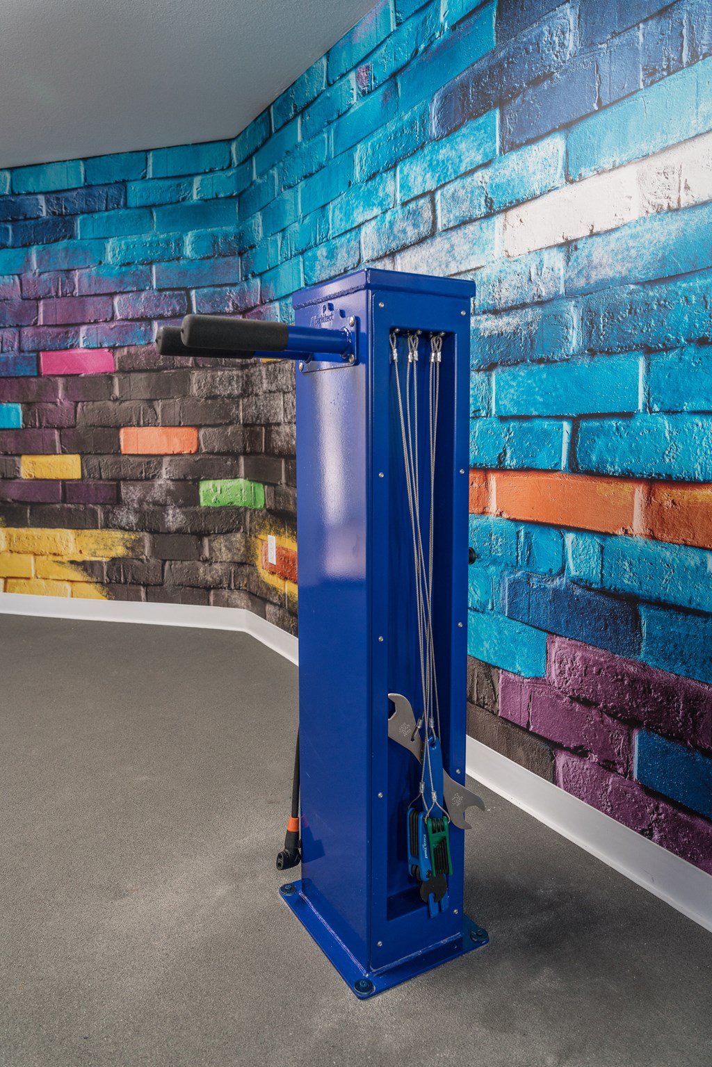 a blue metal elevator in front of a brick wall