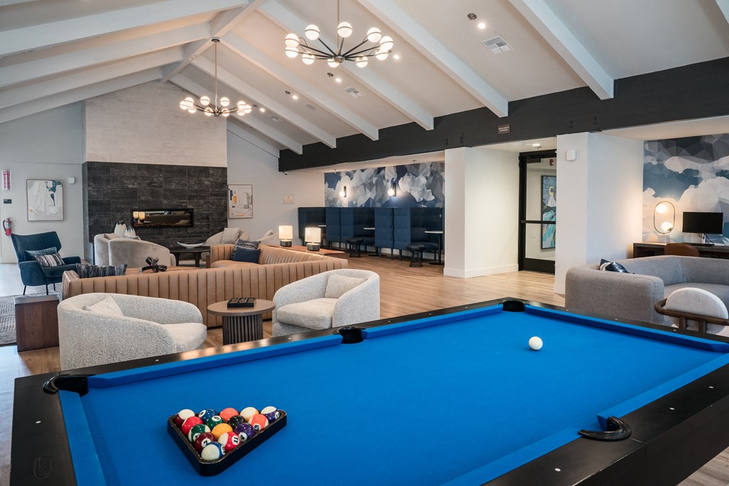 a community room with a pool table and couches