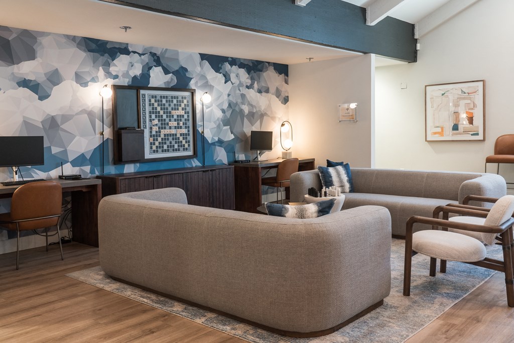 a living room with couches chairs and a desk in a hotel room