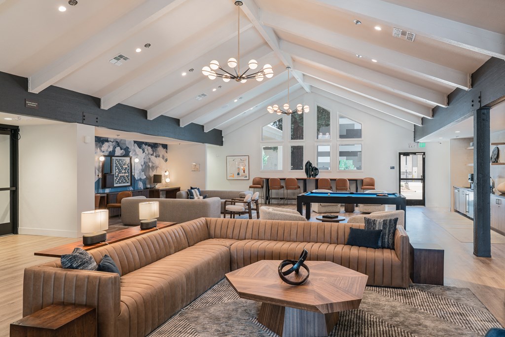 a clubhouse with couches and tables and a pool table