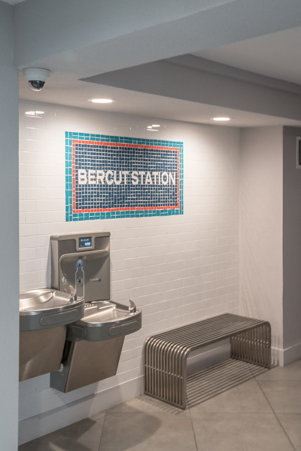 a public restroom with a urinal and a sink and a bench