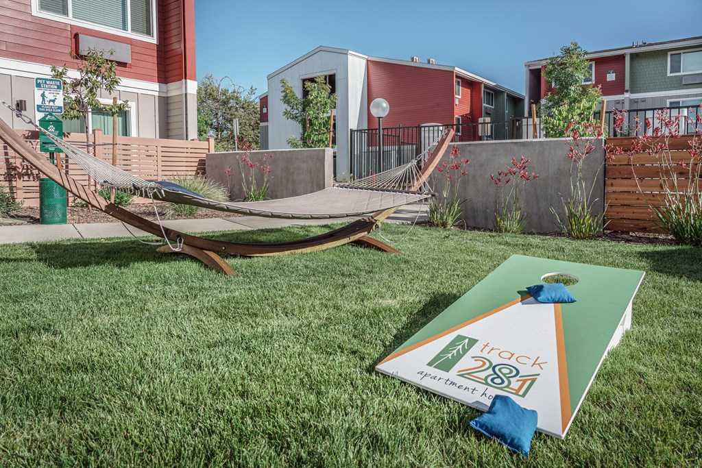 a yard with a hammock and a sign in the grass