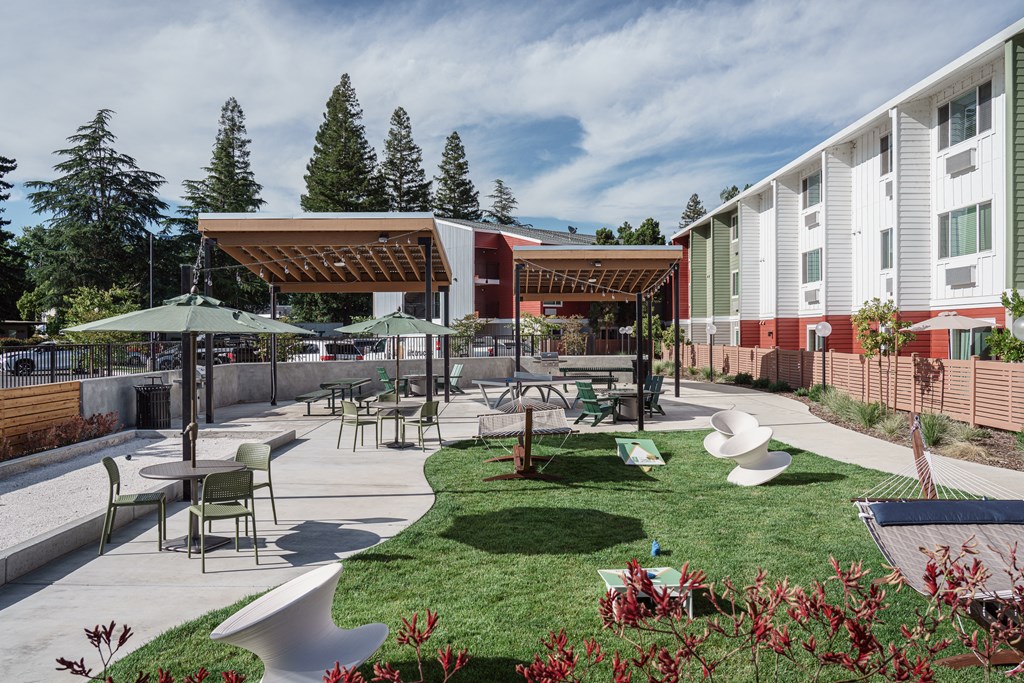 a courtyard with tables and chairs and umbrellas