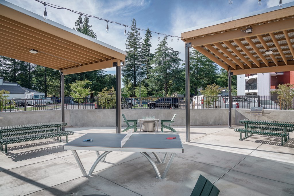 a picnic area with a table and chairs under a canopy