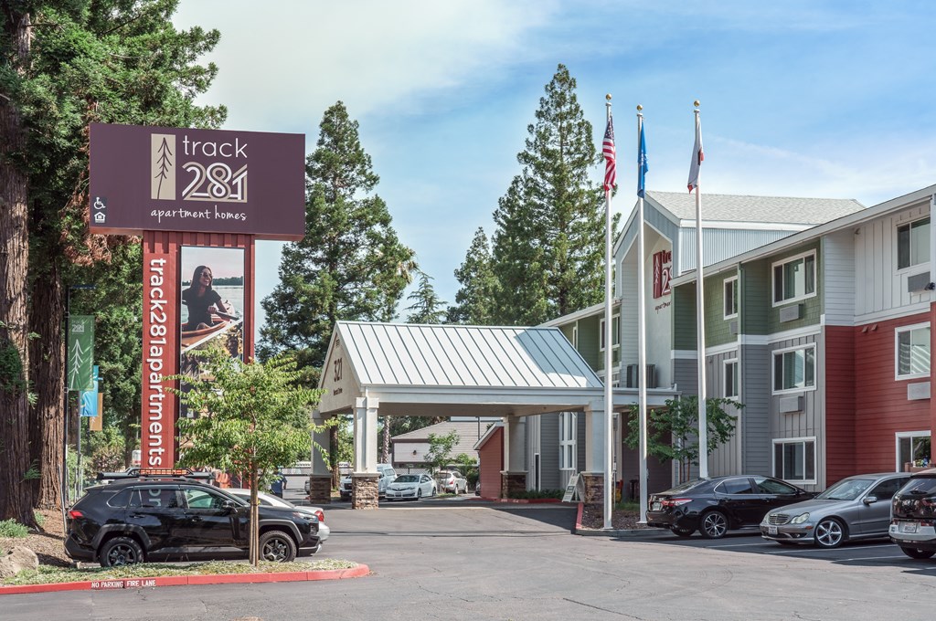 a hotel with a sign and cars parked in front of it