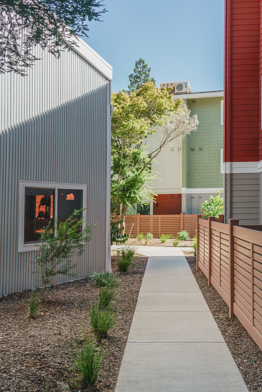 a walkway between two buildings with a fence