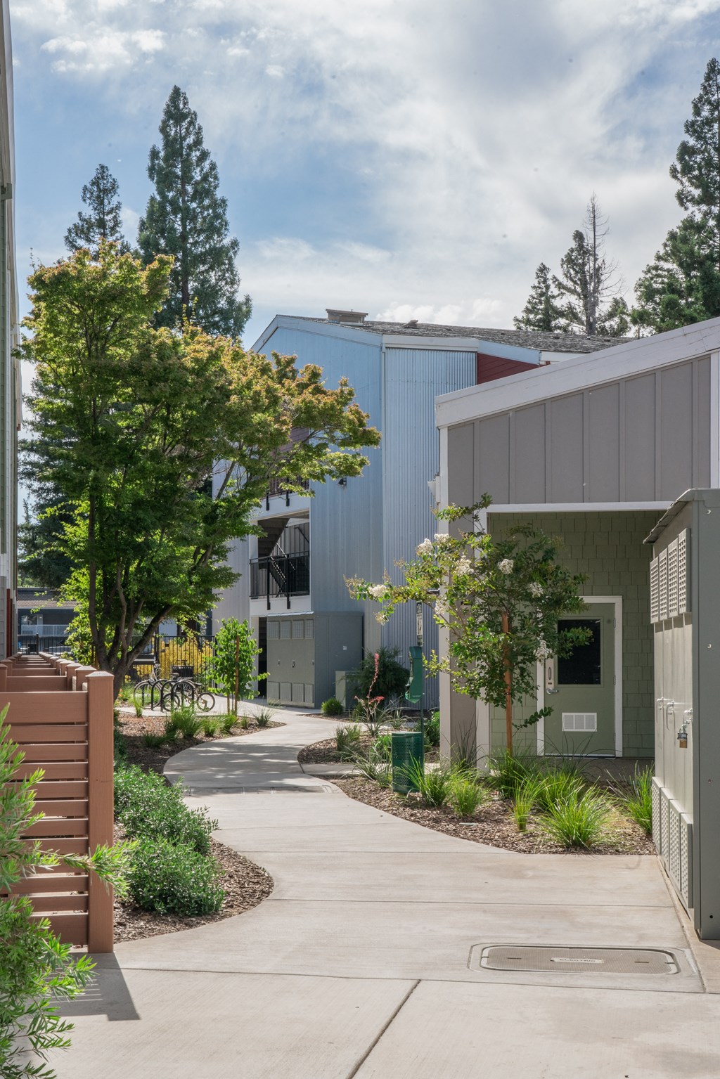 a walkway between two buildings with trees and plants