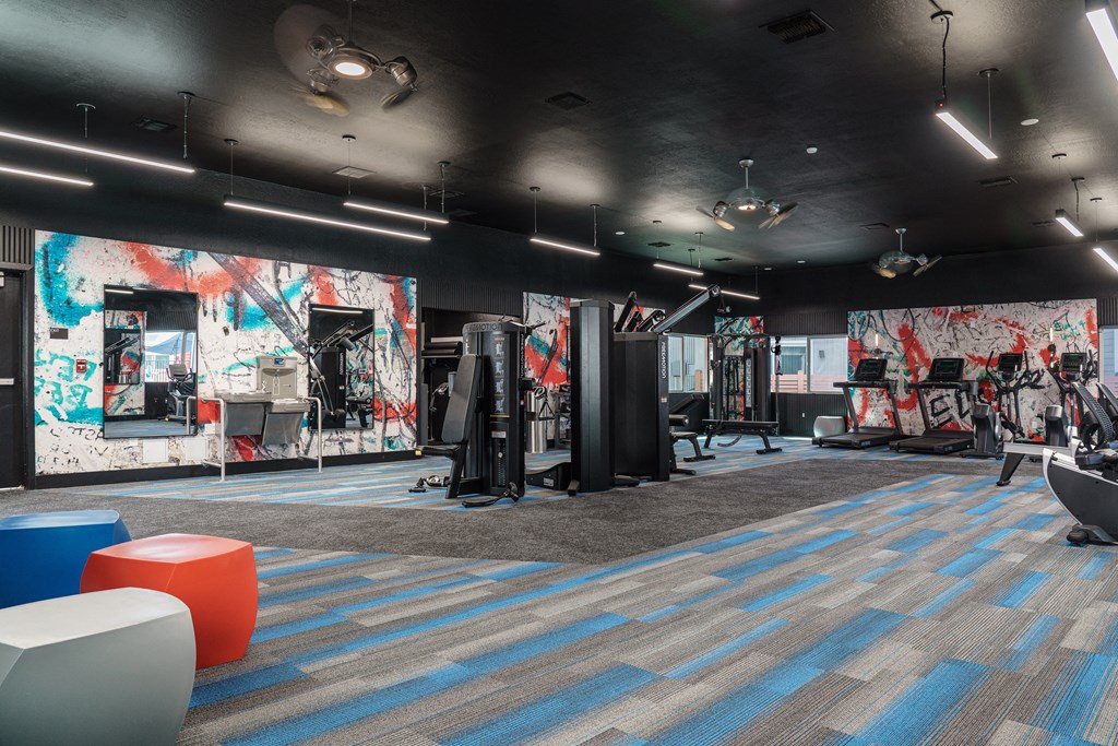 a fitness room with a mural of graffiti on the wall and exercise equipment