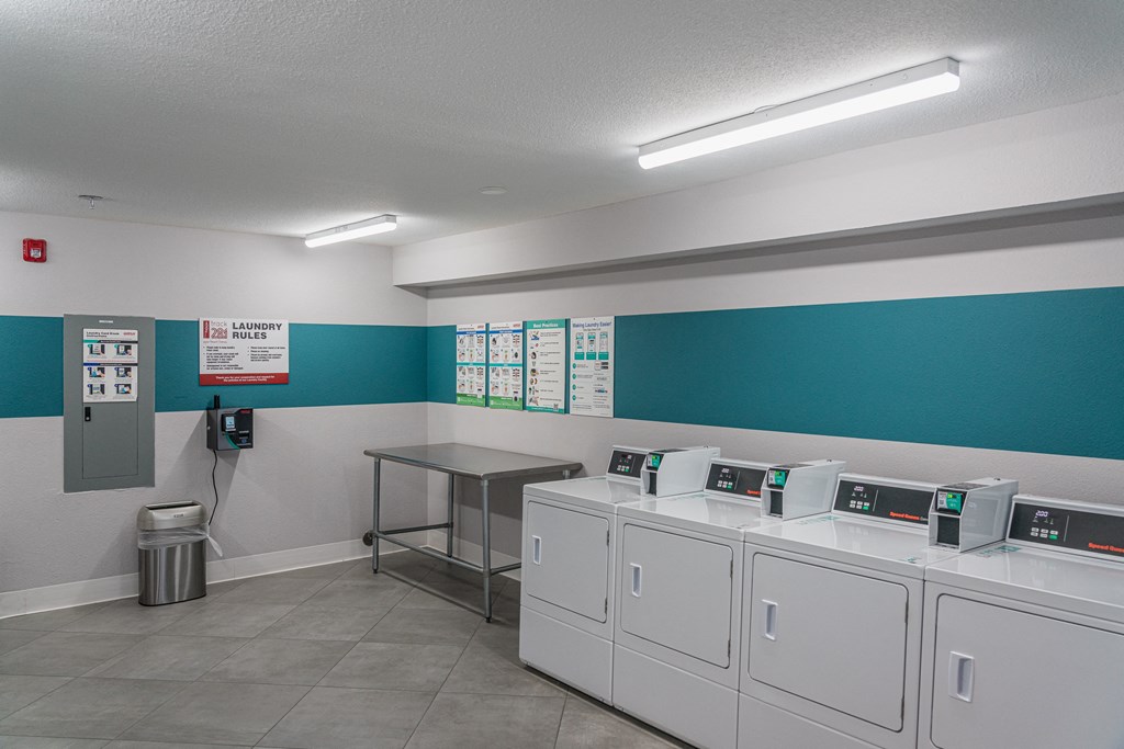 a laundry room with washers and dryers and a table