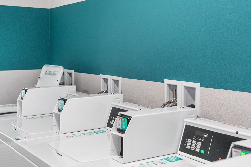 a row of white microwaves in a room with a blue wall