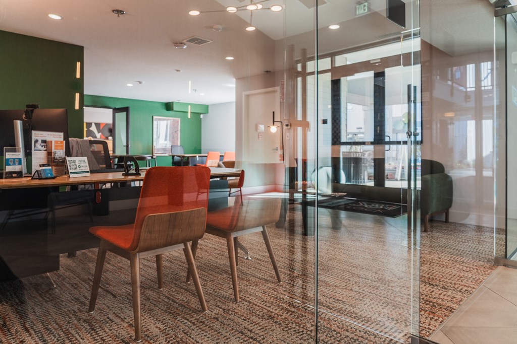 a conference room with glass walls and a table with chairs