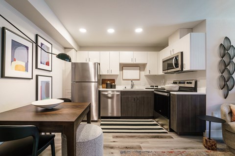 A modern kitchen with a wooden table and chairs.