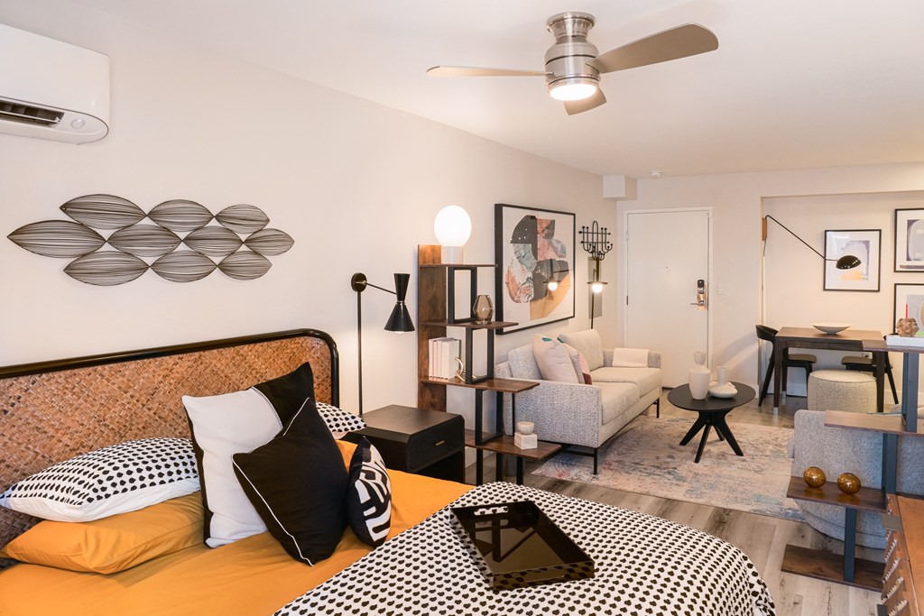 a bedroom with a bed and a living room with a couch