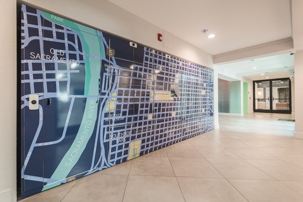 Clubhouse entrance with the community package locker wall painted with a large mural of a Sacramento city map  at Track 281 Apartments, California, 95811