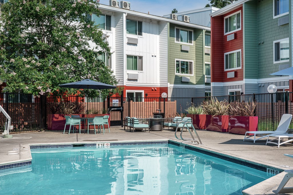 our apartments have a pool and a patio with chairs and tables
