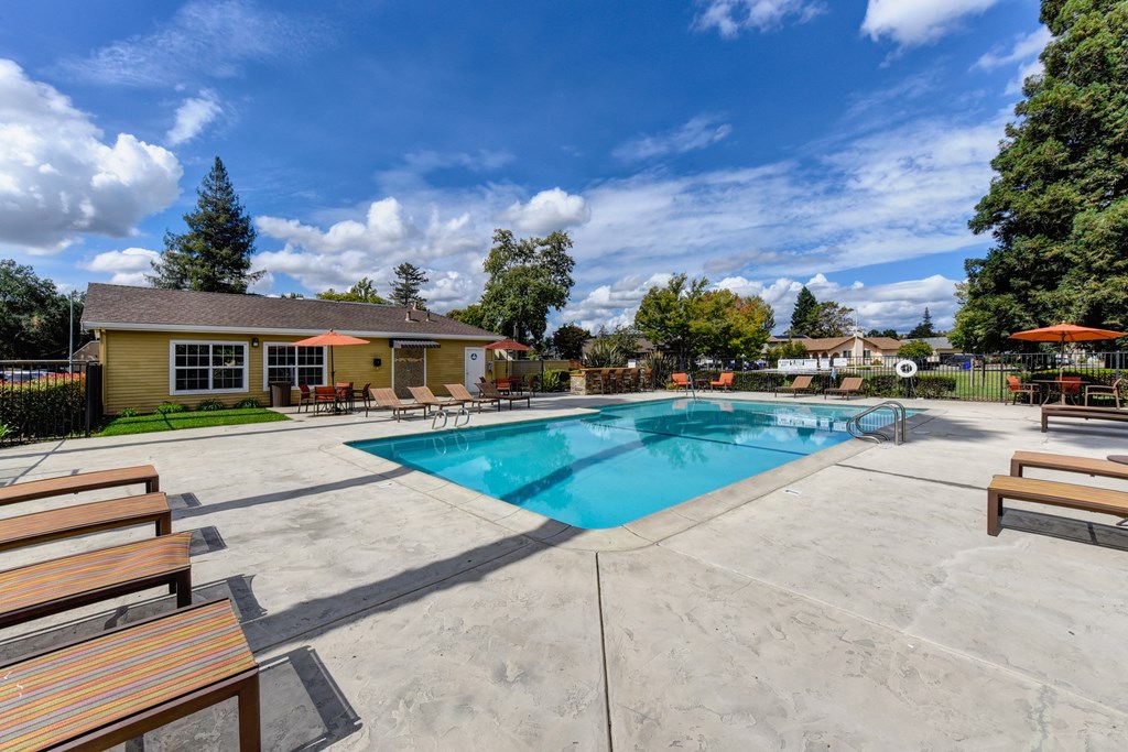 Community swimming pool area and sun deck  with lounge chairs at Vineyard Terrace Apartments, Napa, California