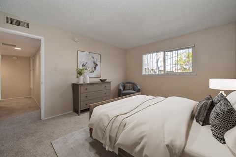 a bedroom with a bed and a dresser and a window