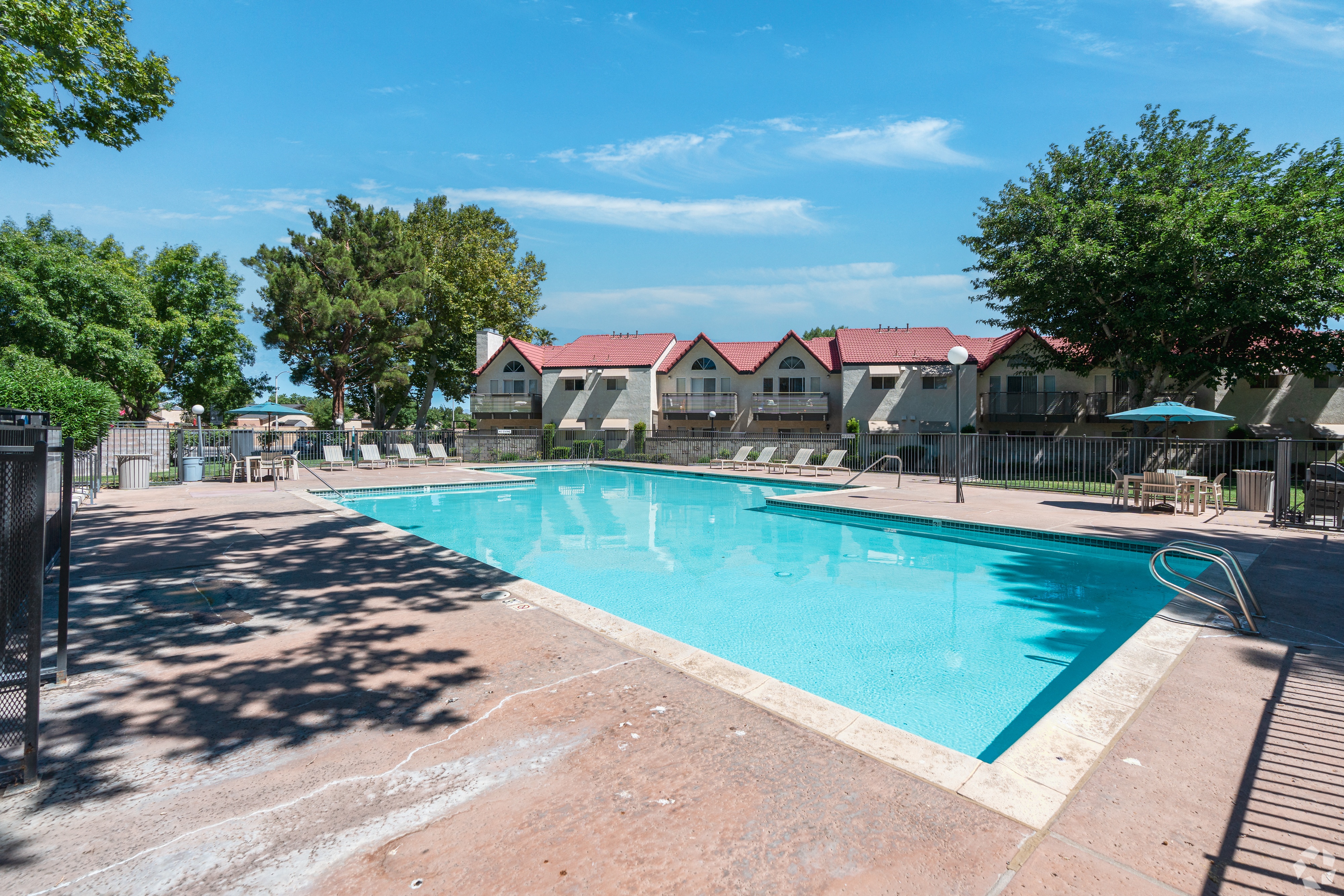 Swimming Pool area with lounge chairs and umbrellas.