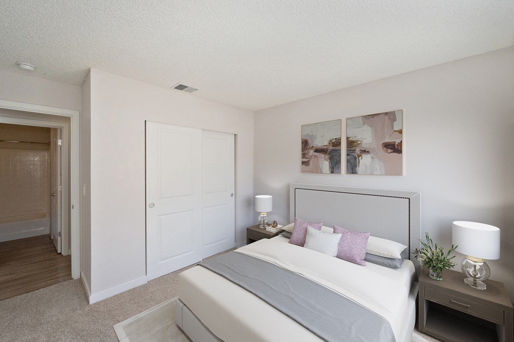West Oaks apartments bedroom with large closet, bed and two nightstands.