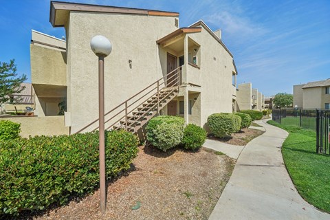 A residential area with apartment buildings and a sidewalk.