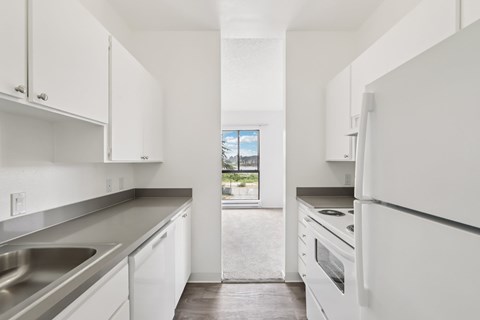 A modern kitchen with white cabinets and stainless steel appliances.