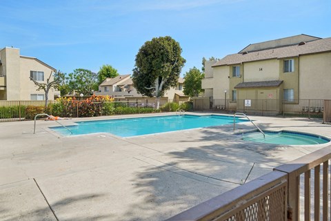 A swimming pool in a residential area with houses in the background.