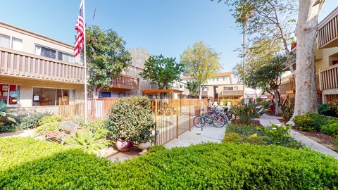 A view of a courtyard with a bicycle and a flag.