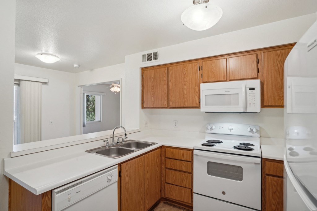 a kitchen with white appliances and wooden cabinets
