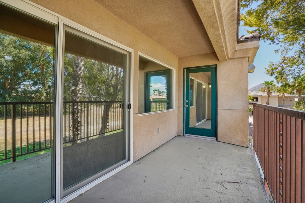 the outlook of a balcony with glass doors and a patio