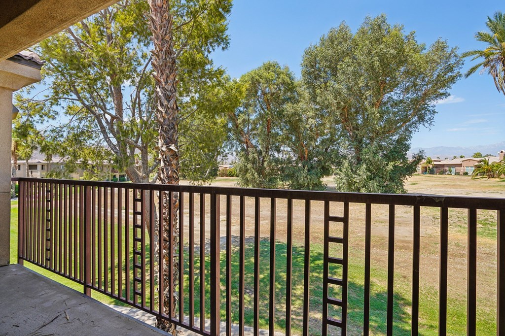a balcony with a view of a yard and trees