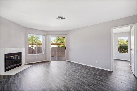 A spacious living room with a fireplace and hardwood flooring.