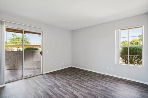 an empty living room with a sliding glass door to a patio