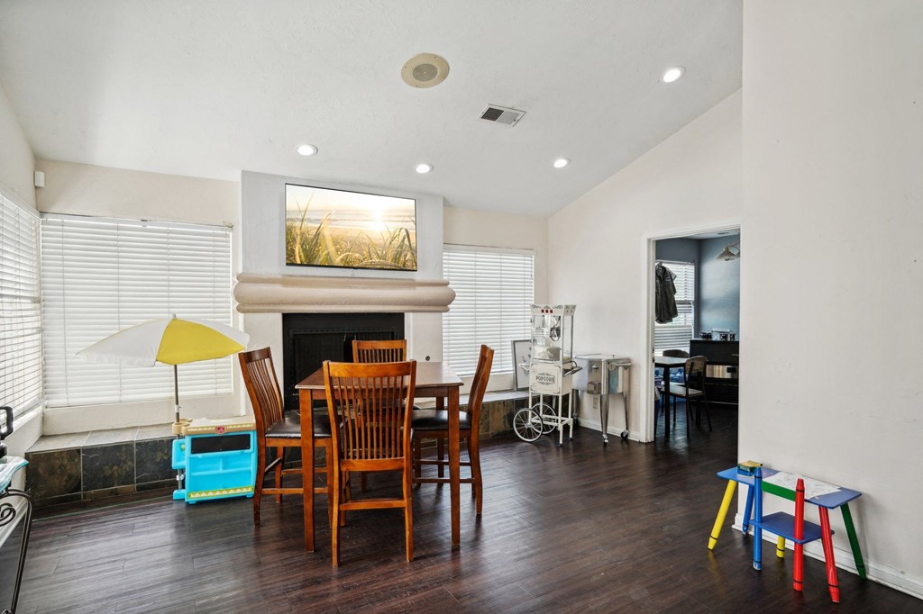 a living room with a table and chairs and a fireplace