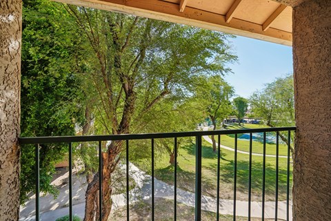 a balcony with a view of a park and trees