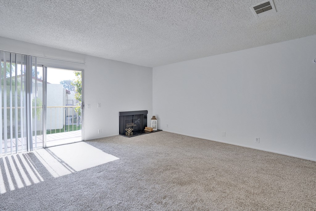 A living room with a fireplace and a carpet.