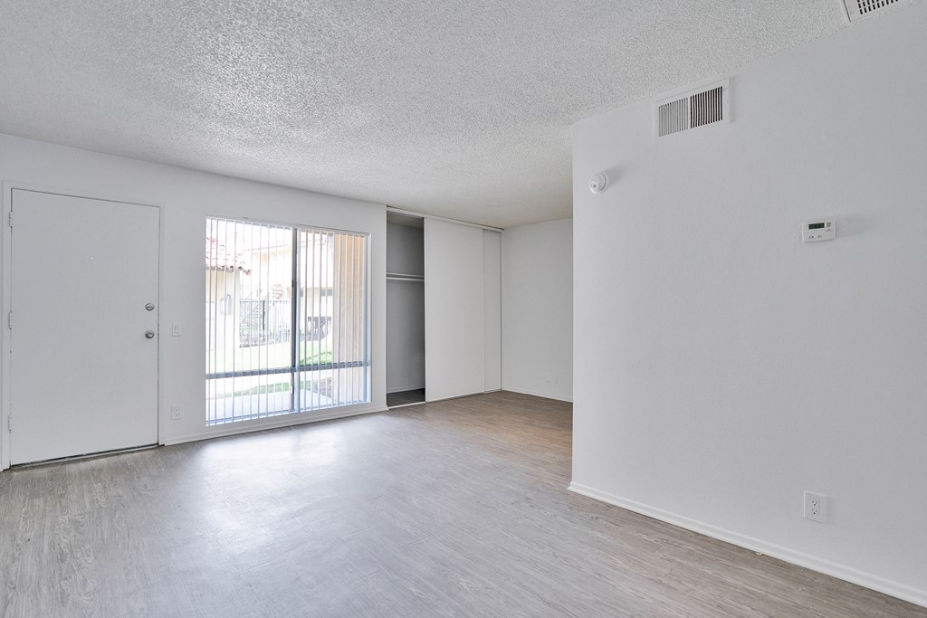 A room with a sliding glass door leading to a balcony.