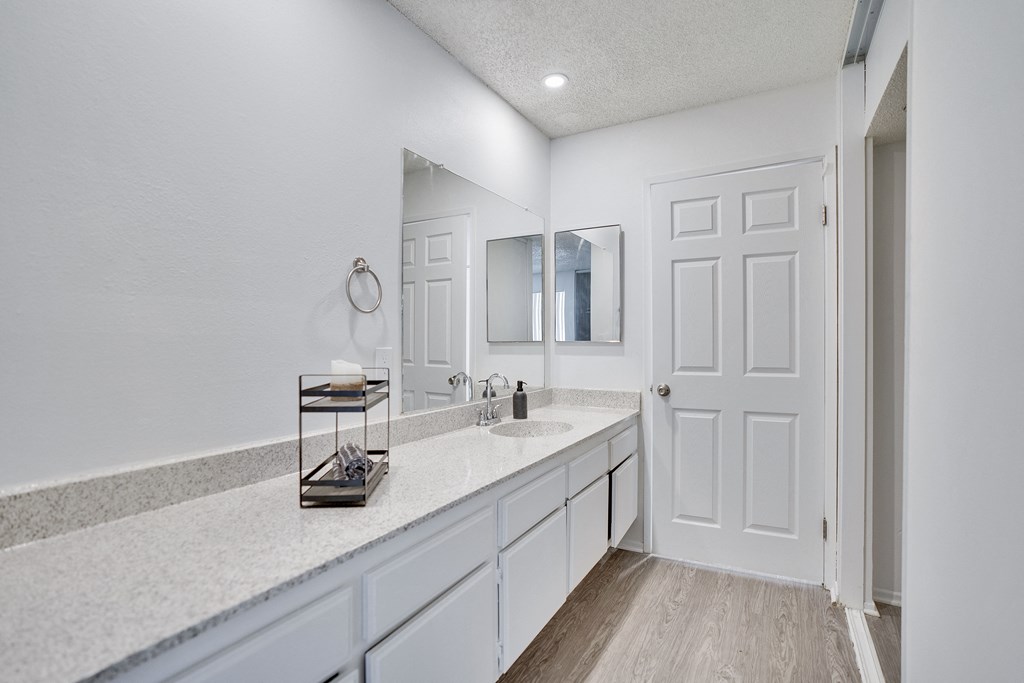 A bathroom with a white sink and a white door.