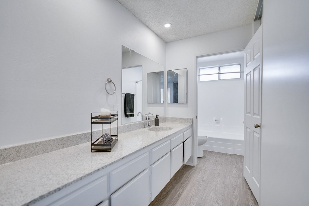 A bathroom with a sink, mirror, and a white door.