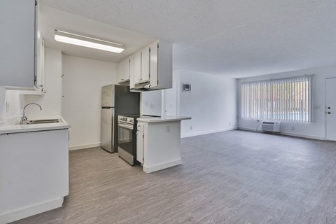 A kitchen with white cabinets and a refrigerator.