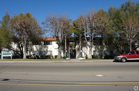 A red car is parked on the right side of the street.