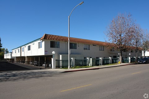 A street view of a building with a red tile roof.