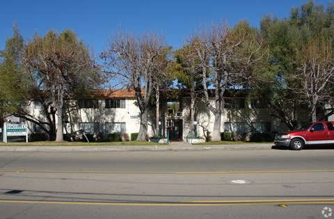 A red car is parked on the right side of the street.