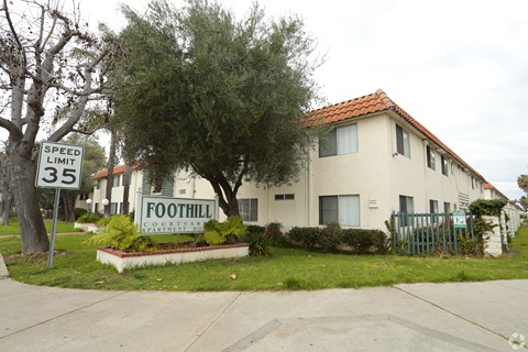 A sign in front of a house that says "FOOTHILL COUNTRY".