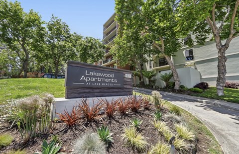 A sign for Lakewood Apartments at Lake Merced is in front of a building.