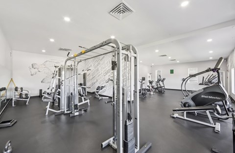 A gym with a variety of equipment including a rowing machine.