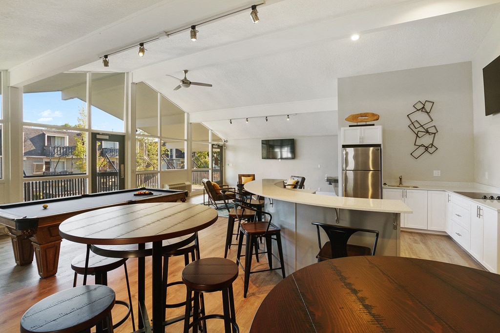 an open kitchen and dining area with a bar and tables