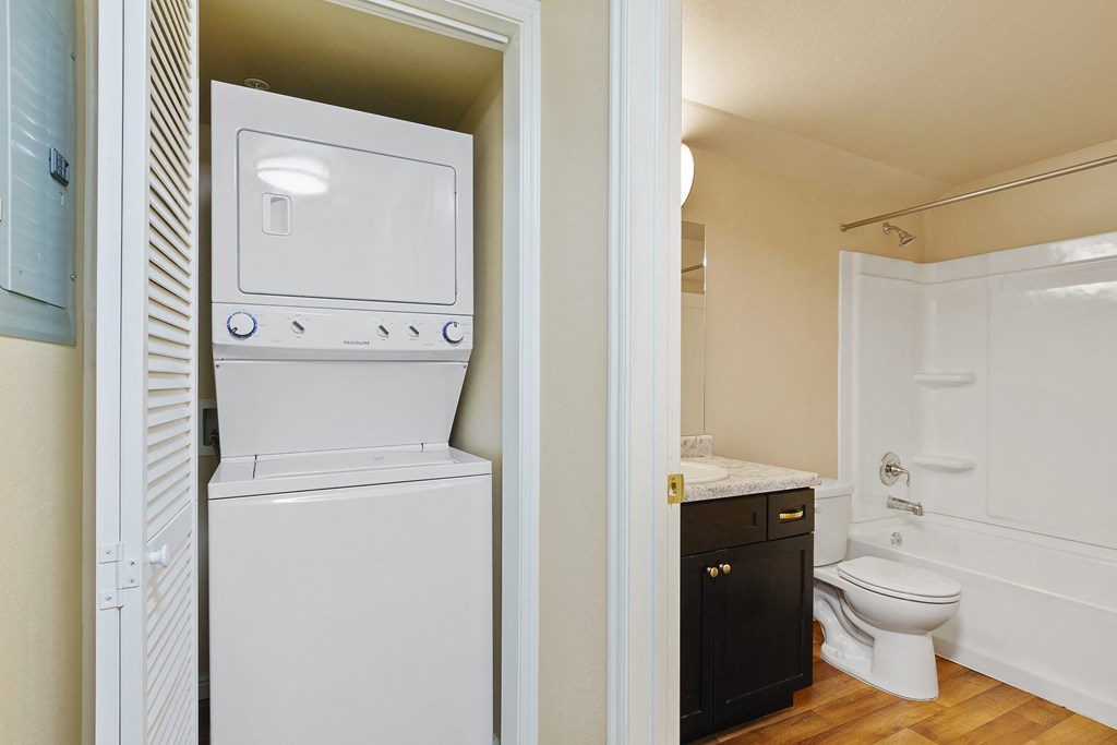 a bathroom with a washer and dryer and a toilet