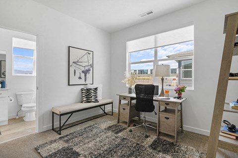 a bedroom with a desk and a window
